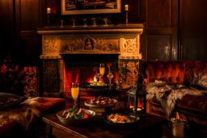 a living room with a fireplace and a table with food at Högberga Gård in Lidingö
