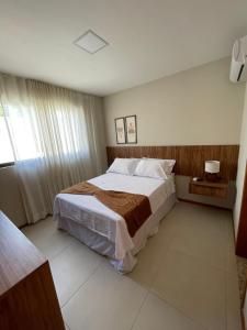 Un dormitorio con una cama grande y una ventana en Mirante da Lagoa 08, en Camassari