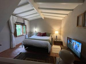 a bedroom with a bed and a flat screen tv at Medieval Tuscan Town House in Lucolena in Chianti