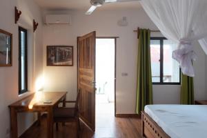 パジェにあるDar Mar Hostel & Coworkingのベッドと机と窓のある寝室