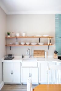 eine Küche mit weißen Schränken und einer Spüle in der Unterkunft 2 Annie's Place Rawdons Country Estate in Nottingham Road + 30 Fotos