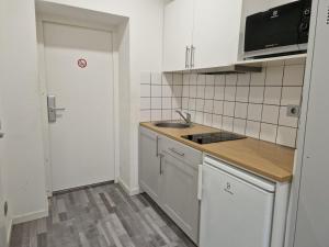 a small kitchen with a sink and a microwave at Moderne Monteurzimmer in Bitterfeld in Bitterfeld