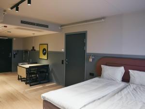 a bedroom with a bed and a table and a desk at Stopover Falkenberg in Falkenberg