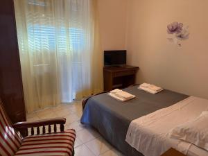 a bedroom with a bed and a chair and a television at Hotel Azzurra in Montecatini Terme +48 photos