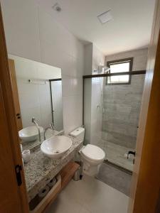 Un baño con inodoro, lavabo y ducha. en Mirante da Lagoa 08, en Camassari