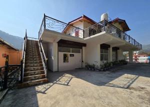 a house with a staircase and a balcony at Shree Dev Asthanam in Bhīm Tāl