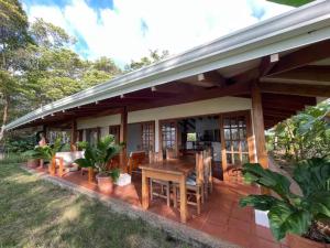 a patio with a wooden table and chairs at Hidden Coast villa Frangipani Ocean & Jungle in Manzanillo