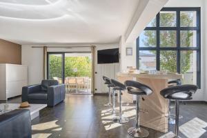 - un salon avec un bar et des tabourets dans l'établissement Villas Odalys Le Domaine d Anadara, à Anglet