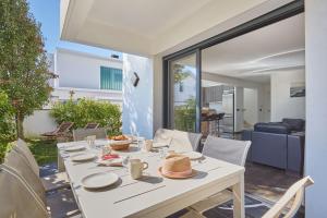 une table blanche avec des chapeaux dessus dans un salon dans l'établissement Villas Odalys Le Domaine d Anadara, à Anglet