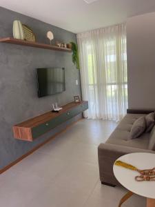 Una sala de estar con un sofá y un televisor de pantalla plana. en Mirante da Lagoa 08, en Camassari 13 fotos más