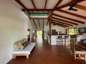 a living room with a couch and a kitchen at Hidden Coast villa Frangipani Ocean & Jungle in Manzanillo
