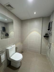 a white bathroom with a toilet and a shower at The Calm Corner Summermall in Kota Samarahan