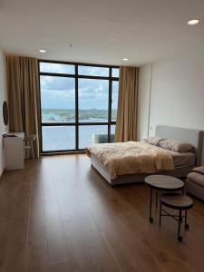 a bedroom with a bed and a large window at The Calm Corner in Kota Samarahan