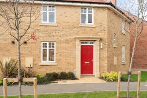 a brick house with a red door at Stylish 3 bed house in Bedford perfect for Contractors and families in Bedford