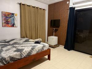 a bedroom with a bed and a lamp and a window at Villa Jade in Dakar