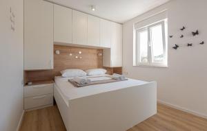 a white bedroom with a large white bed in it at Holiday home Iva by Villas Guide in Vrulje +15 photos