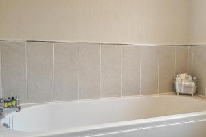 a bath tub in a bathroom with a tiled wall at 2 Bed in Evesham oc-f33689 in Offenham +5 photos