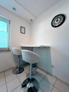 a room with two chairs and a clock on the wall at FeWo Lindenallee V - Geräumiges Apartment in Nordhorn