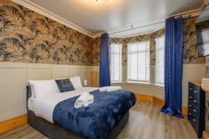 a bedroom with a large bed with blue comforter at Brough Street 4 Bed, 5 Guests in Goole