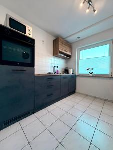 a kitchen with black cabinets and a window at FeWo Lindenallee V - Geräumiges Apartment in Nordhorn