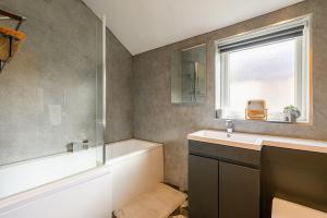 a bathroom with a tub and a sink and a shower at Brough Street 4 Bed, 5 Guests in Goole