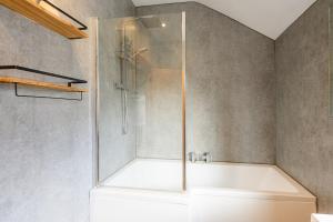 a bathroom with a shower and a bath tub at Brough Street 4 Bed, 5 Guests in Goole