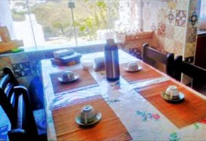 Una mesa con platos y una botella encima. en Hostel Mi Casa Su Casa 1, en Poços de Caldas 4 fotos más