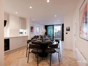una cucina e una sala da pranzo con tavolo e sedie di Solaro at The Heim Residences a Manchester