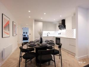 una cucina e una sala da pranzo con tavolo e sedie di Solaro at The Heim Residences a Manchester Altre 31 foto
