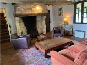 Chaumière 6-8p, 4ch, proche Honfleur في Conteville: غرفة معيشة مع طاولة ومدفأة