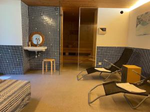 Cette chambre comprend un lit, des chaises et un miroir. dans l'établissement Ferienwohnung Reichart, à Lochau