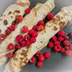 a close up of a plate of food with raspberries at Jauki Lauki in Lejasciems +12 photos