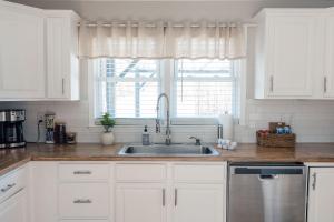 a kitchen with white cabinets and a sink and a window at 3bed 2Bath Home Near ETSU in Johnson City