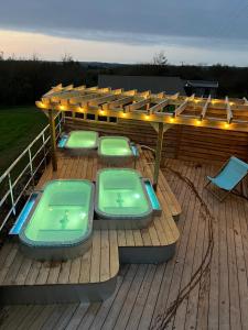 a deck with two hot tubs and a pergola at The Pig Arc in Bude +17 photos
