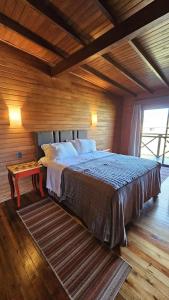 a bedroom with a bed and a wooden wall at Chalet Vinícola D'alture 6 pessoas in São Joaquim