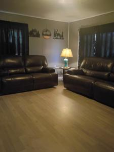 a living room with two leather couches and a lamp at Cozy Cabin Getaway Close to Town in Gladwin