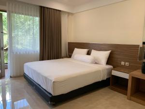 een slaapkamer met een groot bed in een kamer bij The Jayakarta Residence 2BR Bali in Denpasar +8 foto's