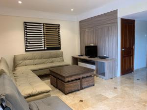 een woonkamer met een bank en een tafel bij The Jayakarta Residence 2BR Bali in Denpasar