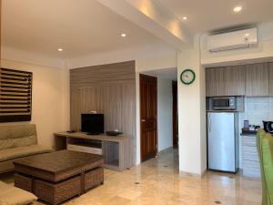 een woonkamer met een bank en een keuken bij The Jayakarta Residence 2BR Bali in Denpasar