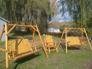 two wooden chairs and swings in a yard at Cozy Cabin Getaway Close to Town in Gladwin +6 photos