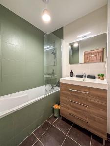 a bathroom with a sink and a tub and a shower at Puilborin, appartement cosy, avec terrasse in Puilboreau +12 photos