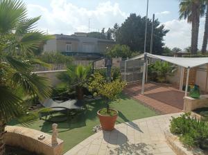 ein Hinterhof mit einer Terrasse mit einem Tisch und einem Baum in der Unterkunft Relais Frantoio delle Pietre in Conversano + 28 Fotos