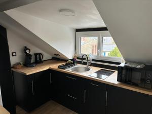 a kitchen with a sink and a window at Petit cocon avec vue sur mer in Dinard