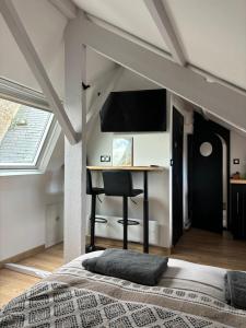 a bedroom with a bed and a desk with a chair at Petit cocon avec vue sur mer in Dinard