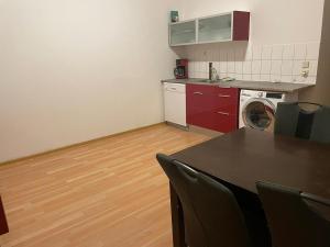 une cuisine avec une table et une machine à laver dans l'établissement Holiday and fitters' apartment near Leipzig in Wurzen, à Niederdorla