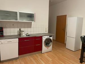 une cuisine avec un lave-linge et un réfrigérateur dans l'établissement Holiday and fitters' apartment near Leipzig in Wurzen, à Niederdorla