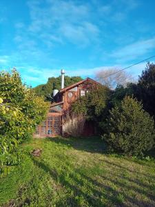 a house with a chimney on top of a yard at Cabaña Punta Mogotes in Mar del Plata