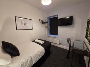 ein Schlafzimmer mit Bett, Schreibtisch und Fenster in der Unterkunft Modern 5 Bedroom Retreat, With Valley Views, Near Bike Park Wales in Troed-y-rhiw + 14 Fotos