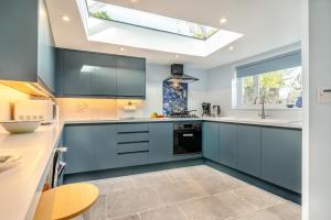 une cuisine avec des armoires bleues et une lucarne dans l'établissement 3 Bed in Minehead oc-r30941, à Minehead