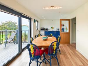 Saint Gennys2 Bed in Crackington Haven oc-h33817的配有木桌椅的厨房和餐厅